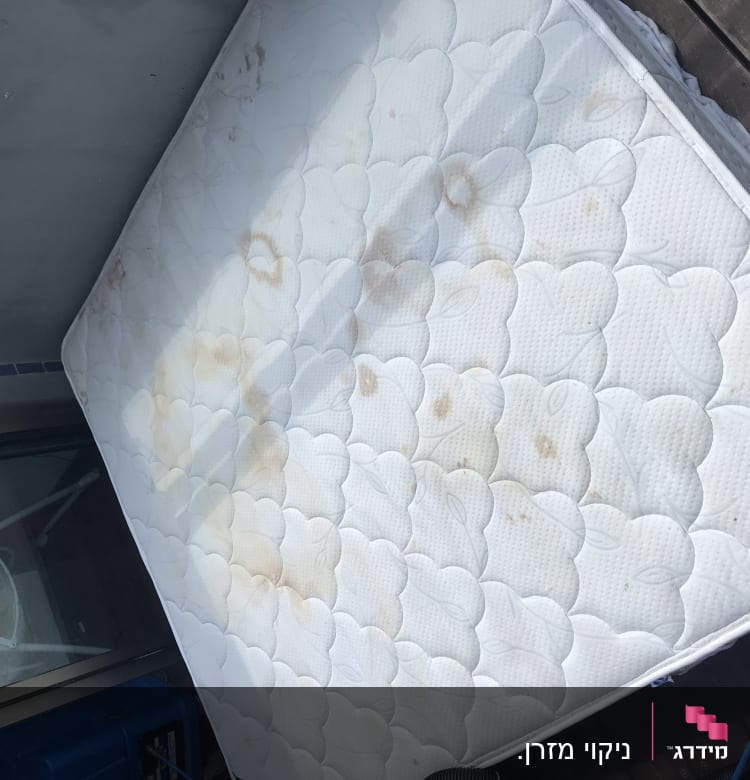 מזרן עם כתמים על מרפסת